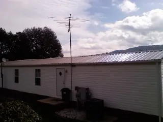 New metal roof on a single wide mobile home with a TV antenna in Sherwood